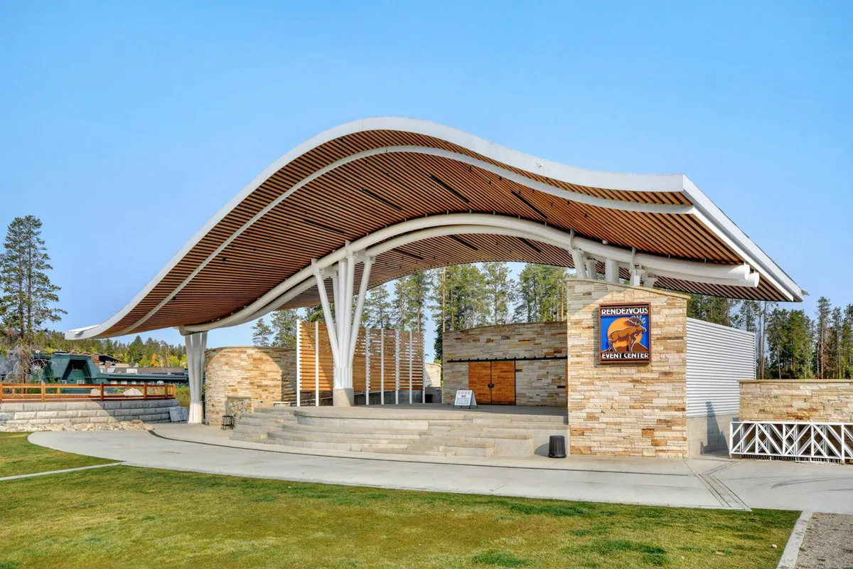 This image captures the curved roof structure and stone wall of an event center, with clear event center signage. The outdoor setting hints at a vibrant community atmosphere, perfectly aligning with concerts and live events mentioned in the section.